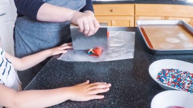 Adım adım. Anne ve kızı mutfakta şekerli kurabiye pişirme.