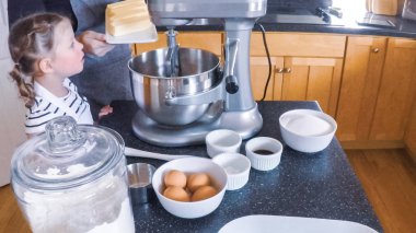 Adım adım. Anne ve kızı mutfakta şekerli kurabiye pişirme.