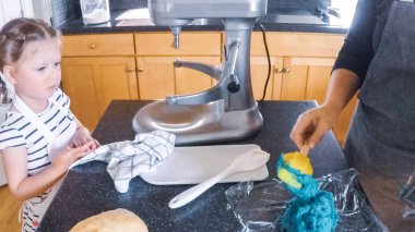 Adım adım. Anne ve kızı mutfakta şekerli kurabiye pişirme.