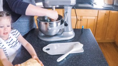 Adım adım. Anne ve kızı mutfakta şekerli kurabiye pişirme.