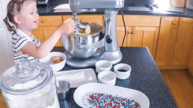 Adım adım. Anne ve kızı mutfakta şekerli kurabiye pişirme.