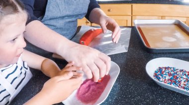 Adım adım. Anne ve kızı mutfakta şekerli kurabiye pişirme.