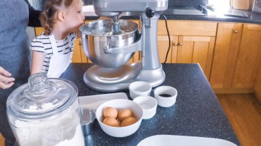 Adım adım. Anne ve kızı mutfakta şekerli kurabiye pişirme.