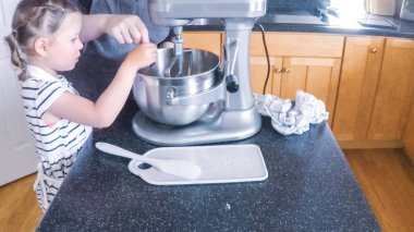 Adım adım. Anne ve kızı mutfakta şekerli kurabiye pişirme.