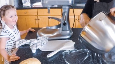 Adım adım. Anne ve kızı mutfakta şekerli kurabiye pişirme.