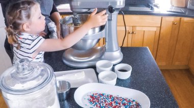 Adım adım. Anne ve kızı mutfakta şekerli kurabiye pişirme.