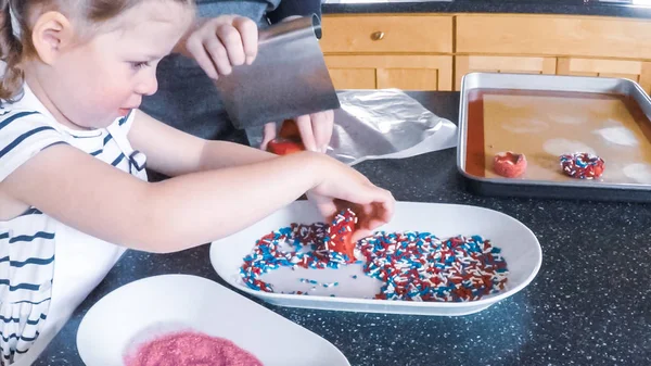 Adım adım. Anne ve kızı mutfakta şekerli kurabiye pişirme.