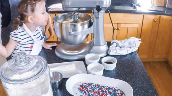 Step by step. Mother and daughter baking sugar cookies in the kitchen.