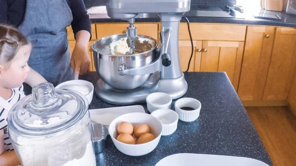 Adım adım. Anne ve kızı mutfakta şekerli kurabiye pişirme.