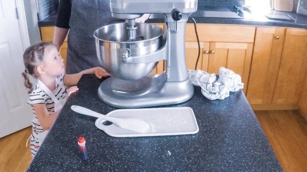 Adım adım. Anne ve kızı mutfakta şekerli kurabiye pişirme.