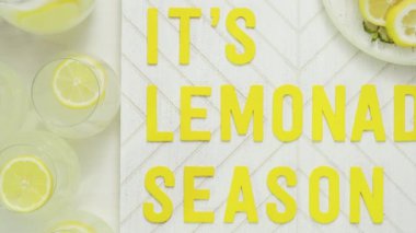 İçerisi limonata sezon ahşap işareti ile taze limon ağaç kesme tahtasında dilimlenmiş.