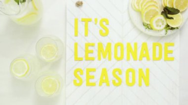 İçerisi limonata sezon ahşap işareti ile taze limon ağaç kesme tahtasında dilimlenmiş.