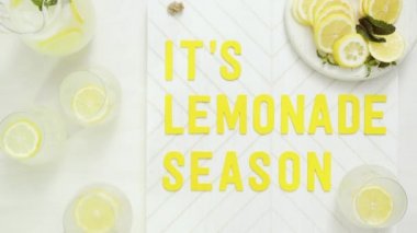 İçerisi limonata sezon ahşap işareti ile taze limon ağaç kesme tahtasında dilimlenmiş.