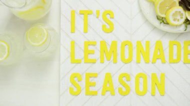 İçerisi limonata sezon ahşap işareti ile taze limon ağaç kesme tahtasında dilimlenmiş.