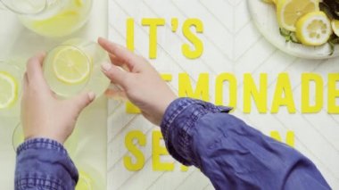İçerisi limonata sezon ahşap işareti ile taze limon ağaç kesme tahtasında dilimlenmiş.