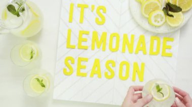 İçerisi limonata sezon ahşap işareti ile taze limon ağaç kesme tahtasında dilimlenmiş.