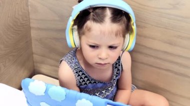 Uzaktan onun tablet üzerinde eğitim katılan kulaklık ile küçük kız