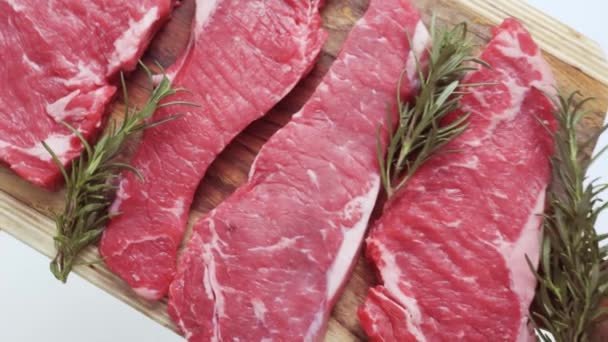 Rohe New York Streifen Steaks Auf Einem Holzschneidebrett — Stockvideo