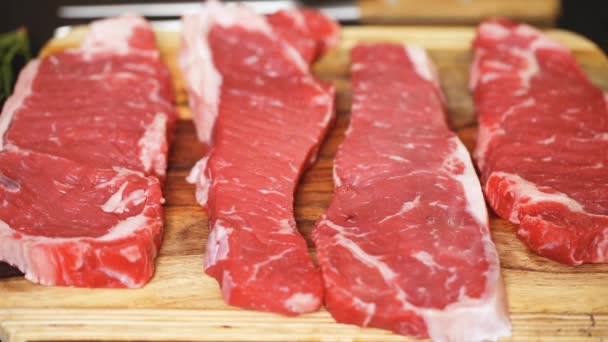 Rohe New York Streifen Steaks Auf Einem Holzschneidebrett — Stockvideo