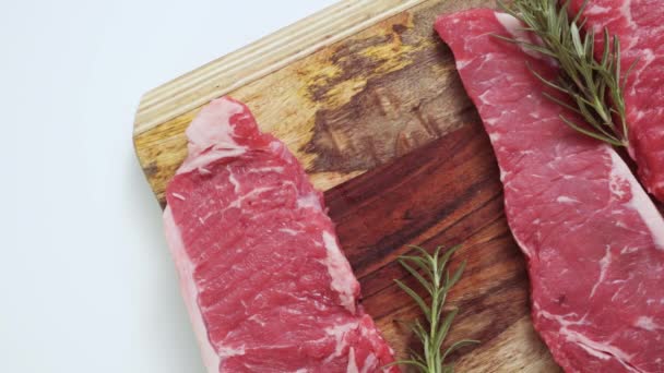 Rauw New York Strip Steaks Een Houten Snijplank — Stockvideo