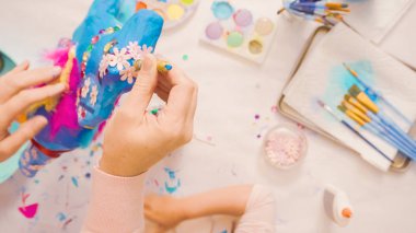 Adım adım. Anne ve kızı dekorasyon kağıt mache tek boynuzlu at birlikte.