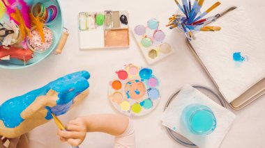 Adım adım. Resim kağıt mache unicorn mavi boya ile.