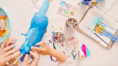 Adım adım. Anne ve kızı dekorasyon kağıt mache tek boynuzlu at birlikte.