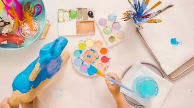 Adım adım. Resim kağıt mache unicorn mavi boya ile.