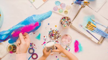 Adım adım. Anne ve kızı dekorasyon kağıt mache tek boynuzlu at birlikte.