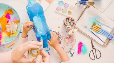 Adım adım. Anne ve kızı dekorasyon kağıt mache tek boynuzlu at birlikte.