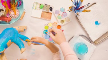 Adım adım. Anne ve kızı dekorasyon kağıt mache tek boynuzlu at birlikte.