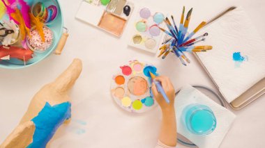 Adım adım. Resim kağıt mache unicorn mavi boya ile.