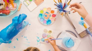 Adım adım. Anne ve kızı dekorasyon kağıt mache tek boynuzlu at birlikte.