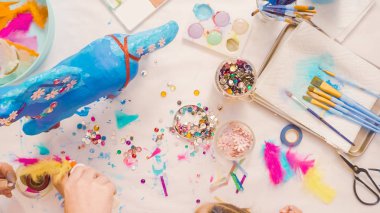 Adım adım. Anne ve kızı dekorasyon kağıt mache tek boynuzlu at birlikte.