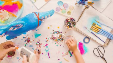 Adım adım. Anne ve kızı dekorasyon kağıt mache tek boynuzlu at birlikte.