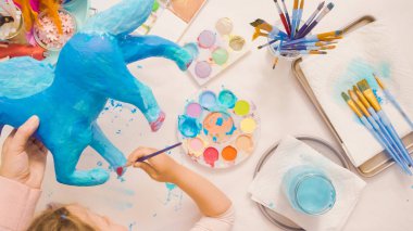 Adım adım. Anne ve kızı dekorasyon kağıt mache tek boynuzlu at birlikte.