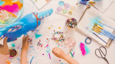 Adım adım. Anne ve kızı dekorasyon kağıt mache tek boynuzlu at birlikte.