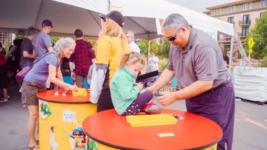 Boulder, Colorado, ABD-Mayıs 28, 2018 - baba ve Lego blokları Boulder Creek Festivali ile oynayan kız.