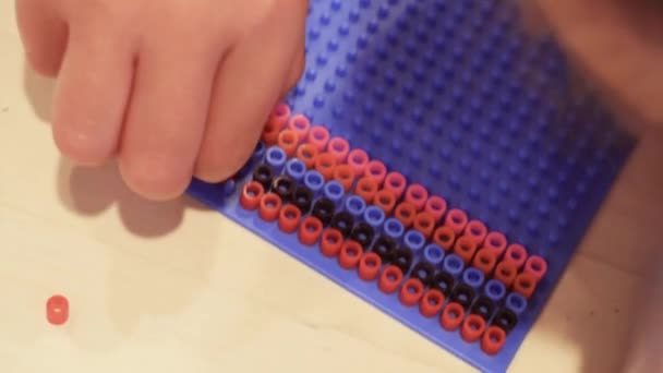 Kleines Mädchen Bastelt Armband Aus Bunten Kinderperlen — Stockvideo