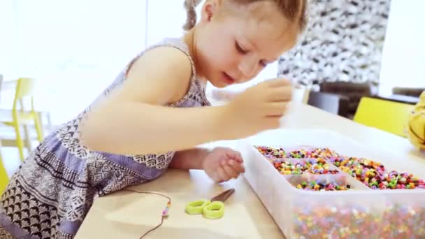 Kleines Mädchen Bastelt Armband Aus Bunten Kinderperlen — Stockvideo