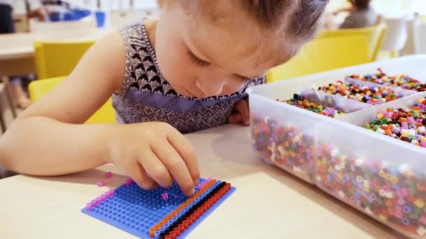 Kleines Mädchen Bastelt Armband Aus Bunten Kinderperlen — Stockvideo