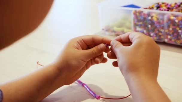 Närbild Barnen Händer Besträngning Färgglada Pärlor För Att Göra Armband — Stockvideo