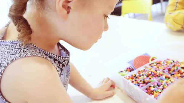 Kleines Mädchen Bastelt Armband Aus Bunten Kinderperlen — Stockvideo