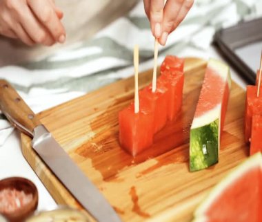 Çikolata ve sprinked deniz tuzu ve badem ile karpuz mezeler hazırlamaya küpleri karpuz Dilimleme daldırma