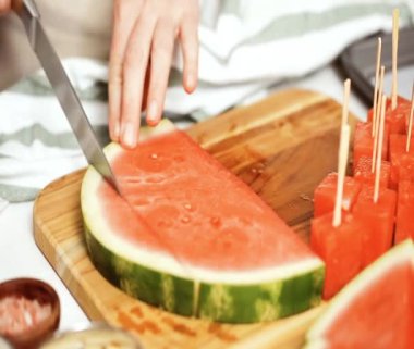 Çikolata ve sprinked deniz tuzu ve badem ile karpuz mezeler hazırlamaya küpleri karpuz Dilimleme daldırma