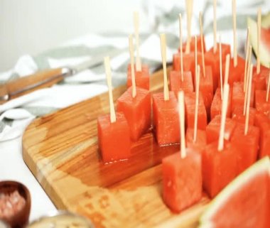 Çikolata ve sprinked deniz tuzu ve badem ile karpuz mezeler hazırlamaya küpleri karpuz Dilimleme daldırma