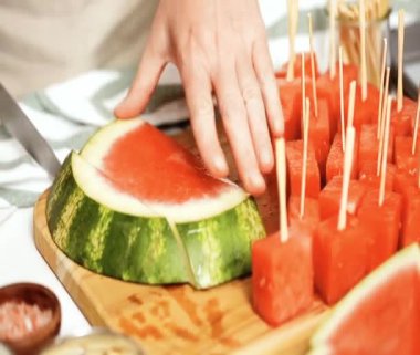 Çikolata ve sprinked deniz tuzu ve badem ile karpuz mezeler hazırlamaya küpleri karpuz Dilimleme daldırma