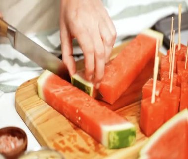 Zaman atlamalı. Çikolata ve sprinked deniz tuzu ve badem ile karpuz mezeler hazırlamaya küpleri karpuz Dilimleme daldırma