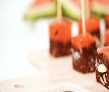 karpuz küpleri içinde eritilmiş çikolata ve deniz tuzu ve badem ile süsleme.
