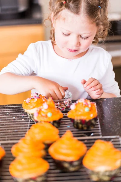 Little Girl Decorating Orange Icing Cupcakes Sprinkle Mix — Stock Photo, Image